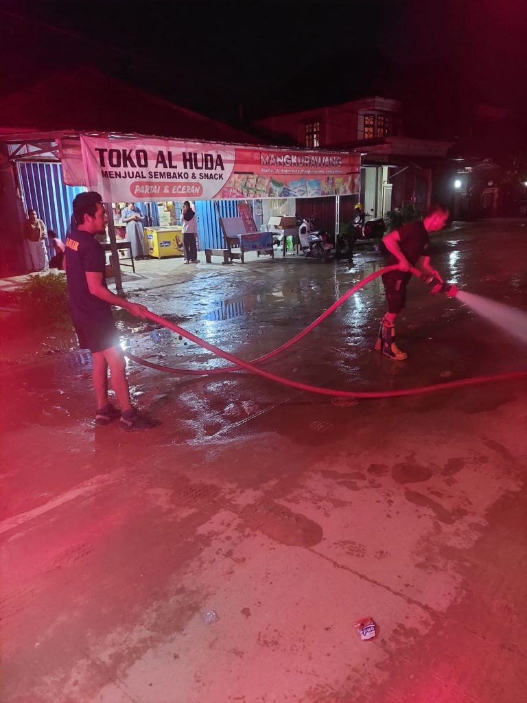 Sinergi Pelayanan, Damkarmatan Kukar Lakukan Penyiraman Jalan di Mangkura­wang